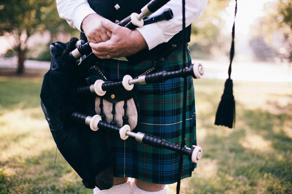 A piper wearing a kilt in a Mackenzie tartan