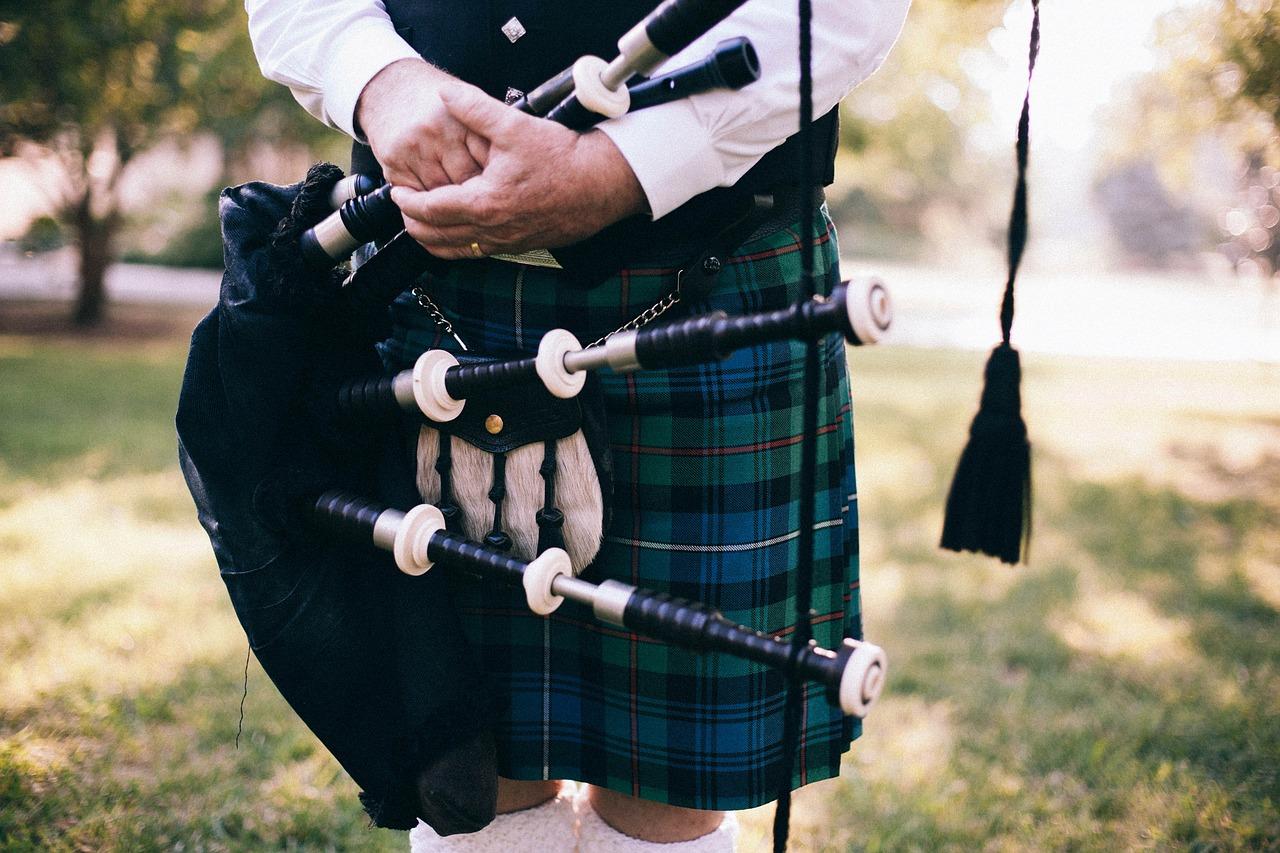 A piper wearing a kilt in a Mackenzie tartan