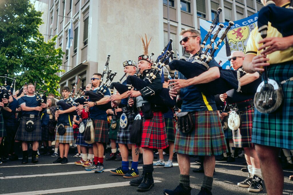 Tartan Army bagpipers march down a street in Boston